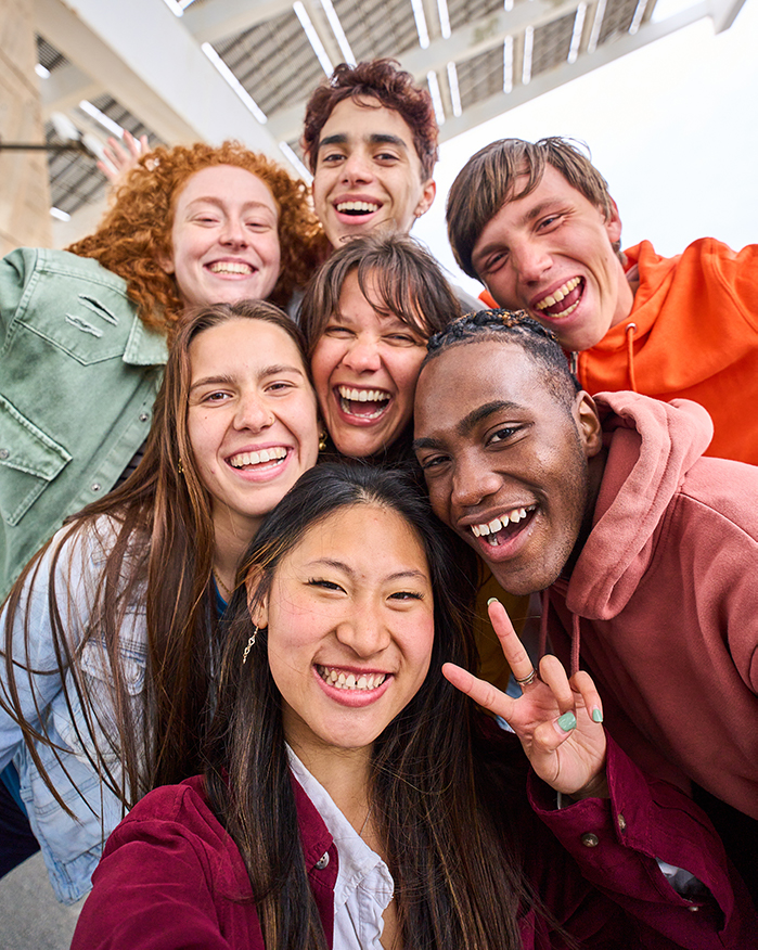 Cheerful group of young adults posing for photo together